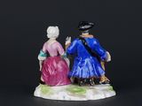 two figurines of a man and a woman sitting on a bench