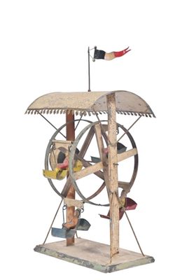 une sculpture en bois représentant un rouet surmonté d'un drapeau