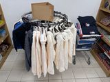 a lot of clothes hanging on a rack in a room
