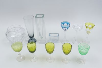 many different colored glasses and vases sitting on a table