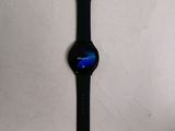 the watch is sitting on a white surface with a black strap