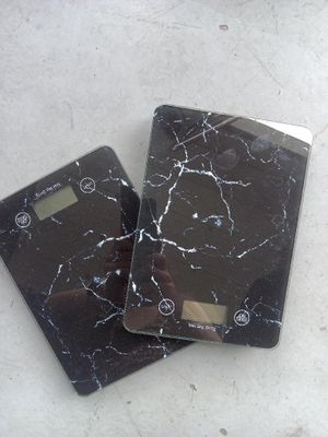 deux balances électroniques posées par terre l'une à côté de l'autre