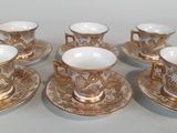 six cups and saucers sitting on a table