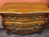 a wooden chest of drawers with brass hardware on it