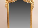 un miroir orné d'un cadre doré sur fond blanc