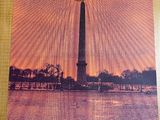 the poster is hanging on the wall of a building with the washington monument in the background