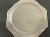 a white plate on a table with a black background
