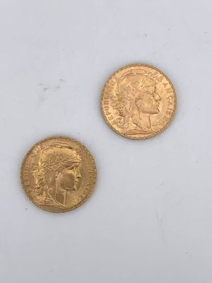 two gold coins sitting next to each other on a white surface