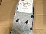 quelqu'un tient une paire de chaussettes qui se trouve dans une boîte