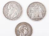 three silver coins, one of which has a woman and one of which has a man on it