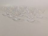 several clear wine glasses are lined up on a white surface
