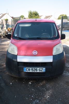 une petite voiture rouge et noire garée sur un parking