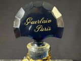 a close up of a bottle of perfume with a chain around it