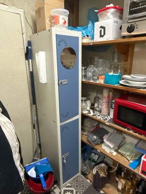 a refrigerator in the corner of a room with a lot of clutter on the floor