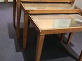 three tables with glass tops sitting on a carpeted floor