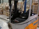 a fork lift truck parked in a warehouse with boxes on the floor