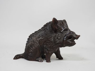 a small statue of a boar sitting on a white surface