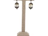 a close up of a pair of earrings on a stand