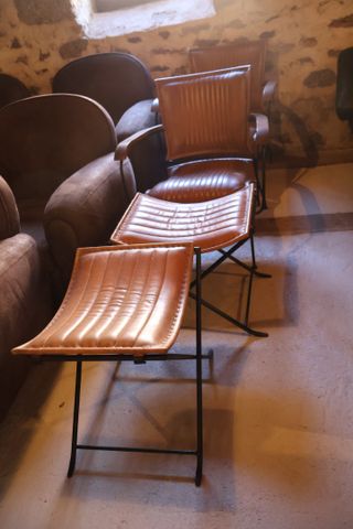 Deux fauteuils métal laqué noir garni de cuir piqué marron avec c...