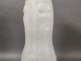 a white vase sitting on a table with a gray background