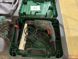 a green box with a drill and a cord in it