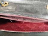 a black purse with a red lining on a table
