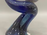 a blue glass sculpture with a ball on top of it