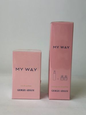 a pink box with a bottle of perfume next to it on a white surface