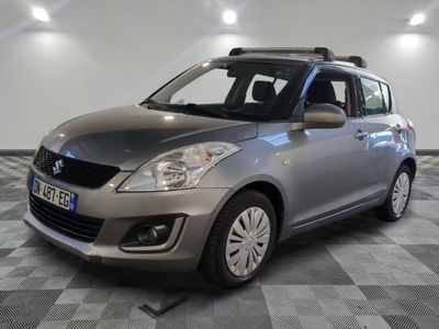 the small silver car is parked on a checkered tile floor