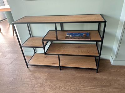 une étagère avec des livres, dans un coin de la pièce