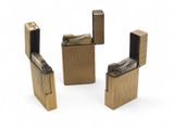 three gold colored lighters sitting next to each other on a white surface