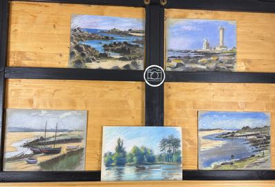 quatre tableaux accrochés au mur d'une pièce où se trouve une horloge