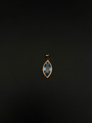 un pendentif en or orné d'une topaze bleue sur fond noir