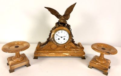 a clock and two candlesticks sitting on a table