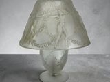 a glass lamp with a white shade on it