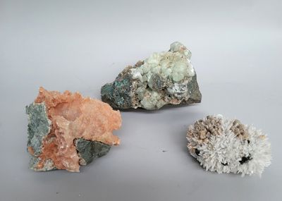 trois pierres de couleurs différentes posées sur une surface blanche
