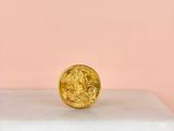 a gold coin sitting on top of a marble block