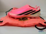 adidas soccer cleats in pink and black on top of an orange bag