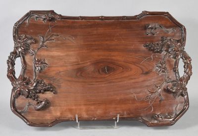 un plateau ancien en bois orné d'un motif sculpté
