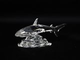 figurine of a glass shark on a black background
