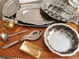 a table with silver plates and silver spoons on it