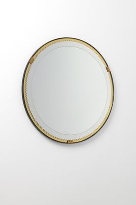 Le miroir rond est accroché au mur de la pièce.
