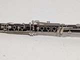 a black and silver clarinet sitting on a white surface
