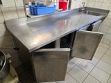 un plan de travail en acier inoxydable sur lequel se trouvent un évier et une casserole