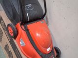 une tondeuse à gazon orange posée sur un carton