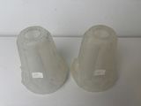 two plastic vases sitting on a white surface