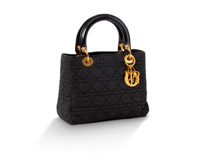 un sac à main noir avec des finitions dorées sur fond blanc