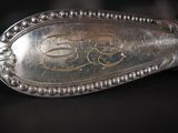 a silver spoon with a monogram on it on a table