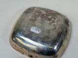 a silver object on a white surface with a sticker on it
