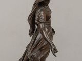 statue of a woman holding a bird in her hand on a table